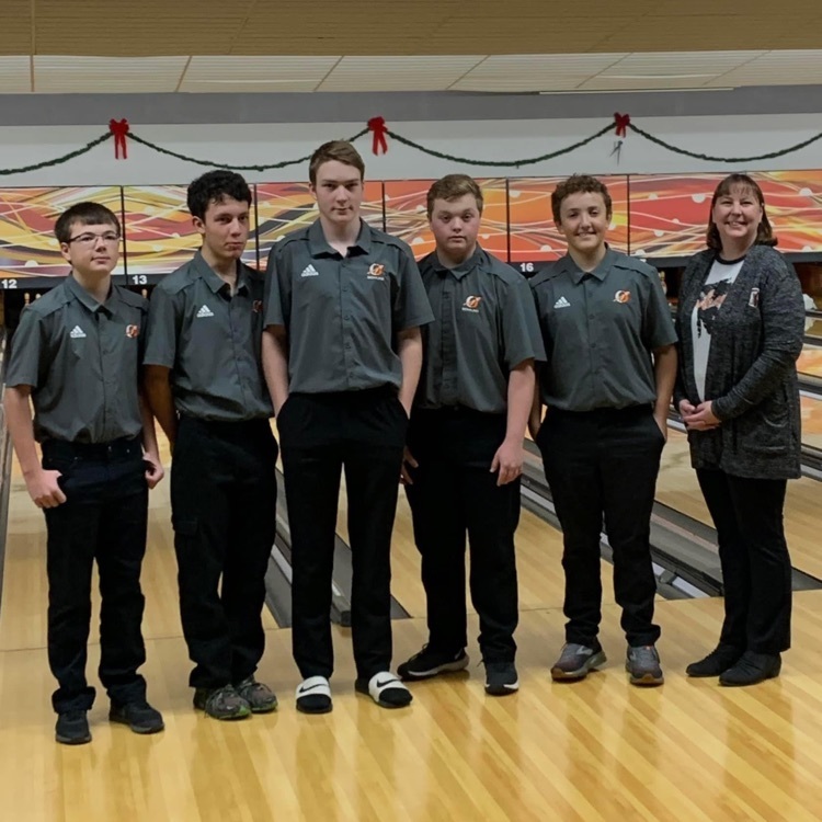 bowlers and coach posing for photo at bowling alley 